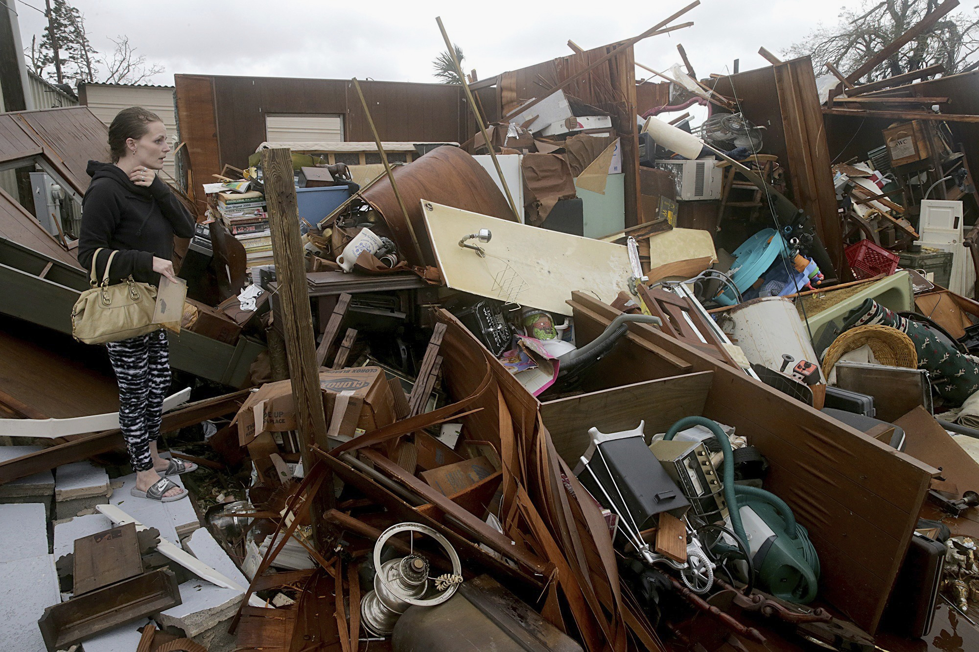 Haley Nelson inspects damages to her family properties in the Panama City, Fla., spring field area after Hurricane Michael made landfall in Florida's Panhandle on Wednesday, Oct. 10, 2018. Supercharged by abnormally warm waters in the Gulf of Mexico, Hurricane Michael slammed into the Florida Panhandle with terrifying winds of 155 mph Wednesday, splintering homes and submerging neighborhoods before continuing its march inland. (Pedro Portal/Miami Herald via AP)