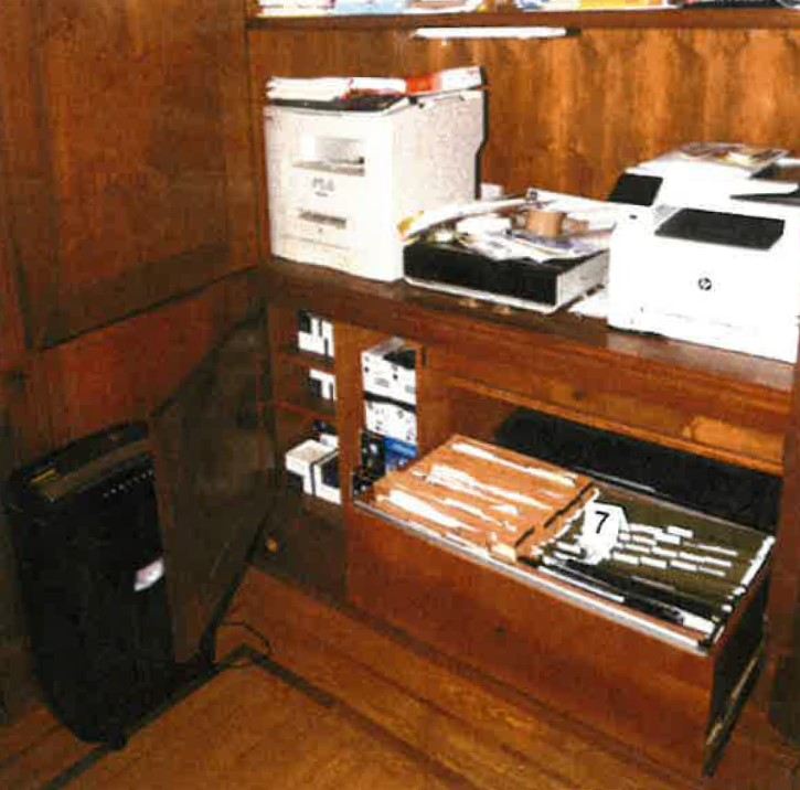 Шкаф под принтерите в офиса на главния етаж на дома в Делауеър, съдържащ три иззети тетрадки